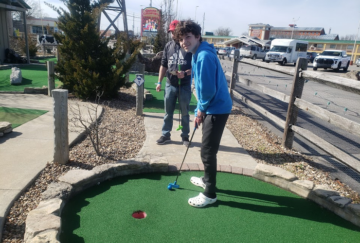 Teen playing mini-golf