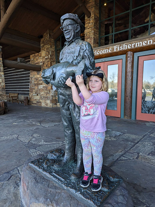 girl with a statue of Uncle Buck at Bass Pro