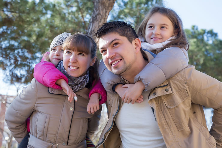 Parents with kids riding piggyback