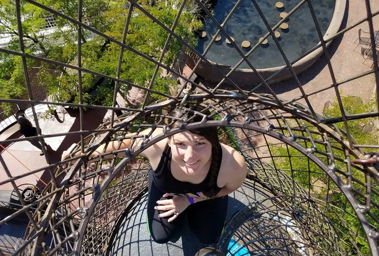 woman looking up inside climbing sculpture at the city museum