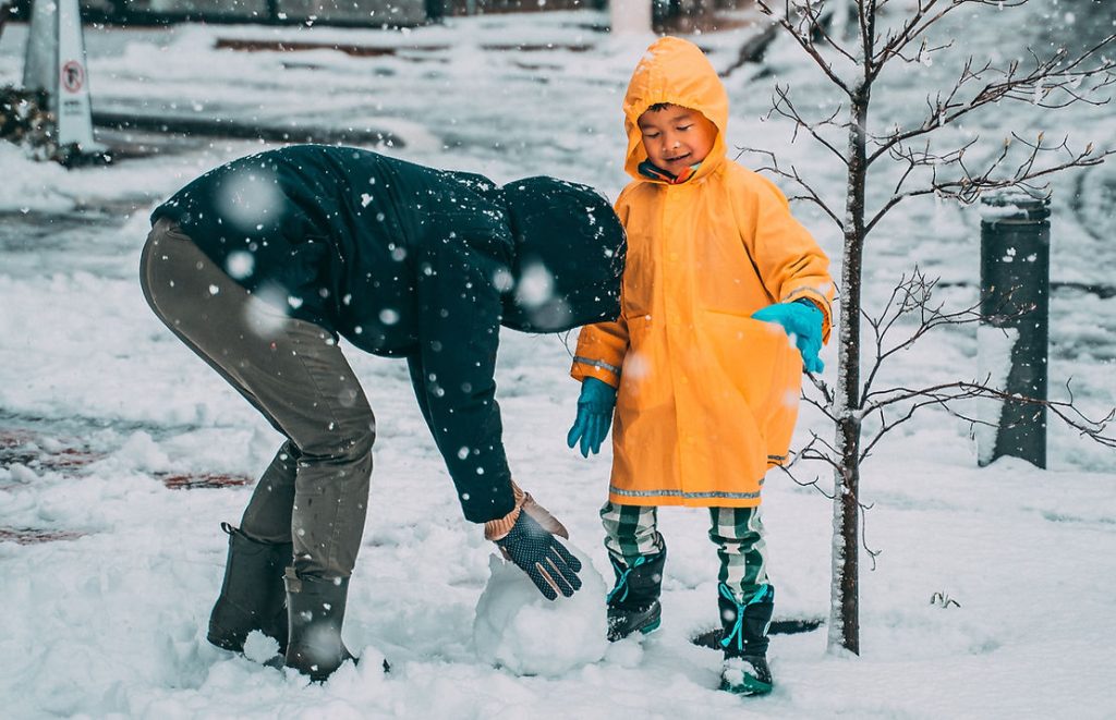 parent and child playing in the snow