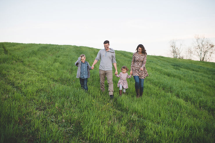 family walking trough grass