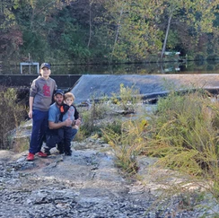 Family posing with bridge in background