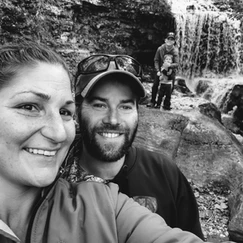 Family posing with waterfall in background.