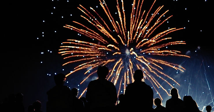 silhouettes of people watching fireworks