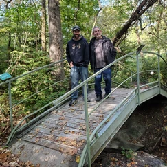 Men walking across small bridge